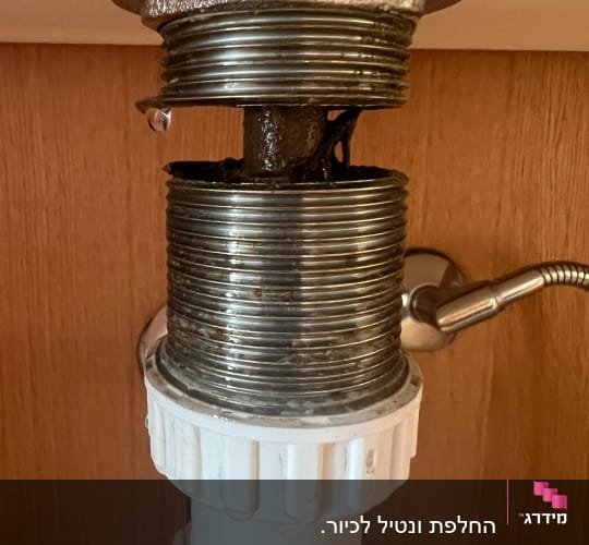צינור מתכת עם נזילה מתחת לכיור